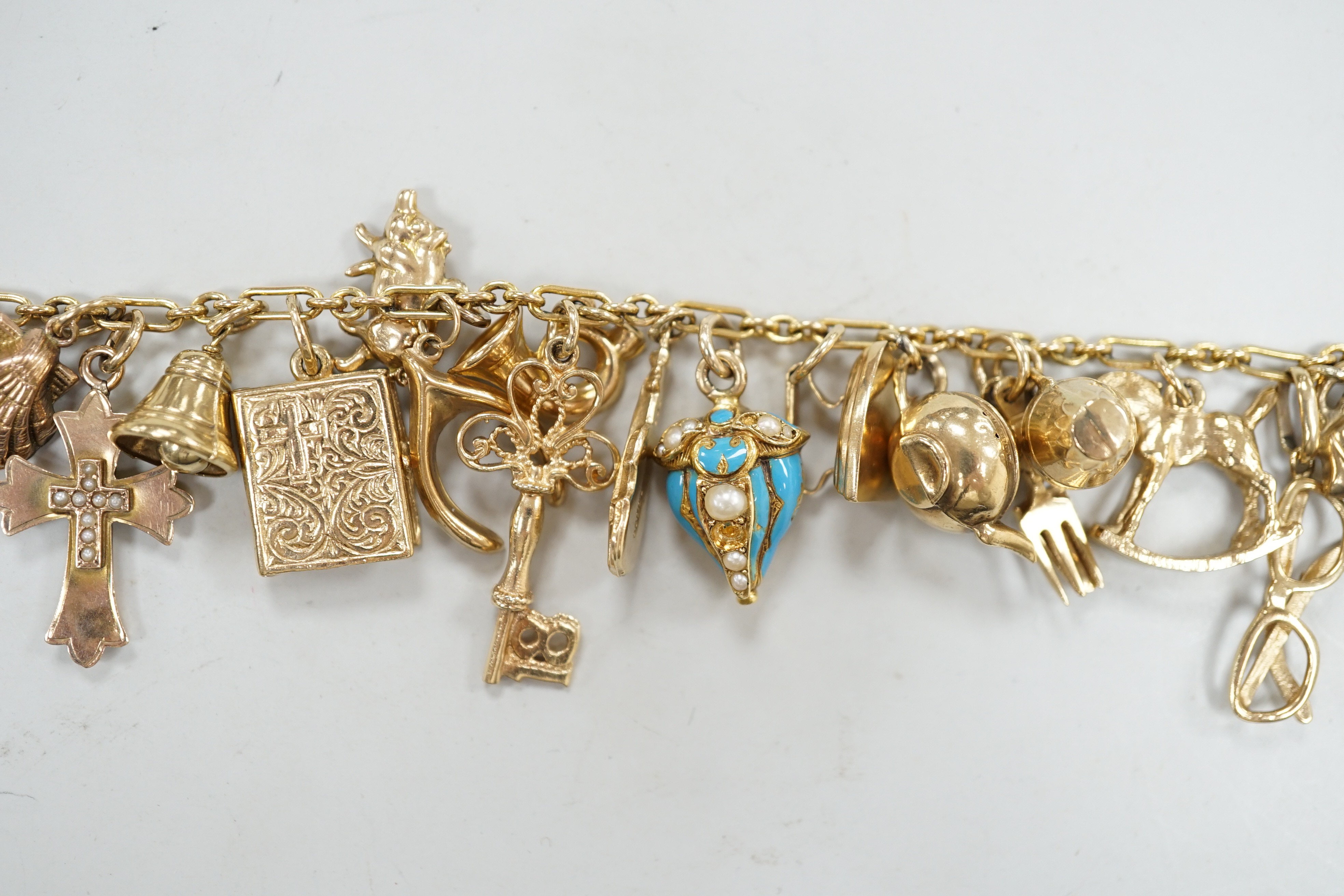 A 9ct charm bracelet, hung with assorted mainly 9ct gold charms, gross weight 46.1 grams.